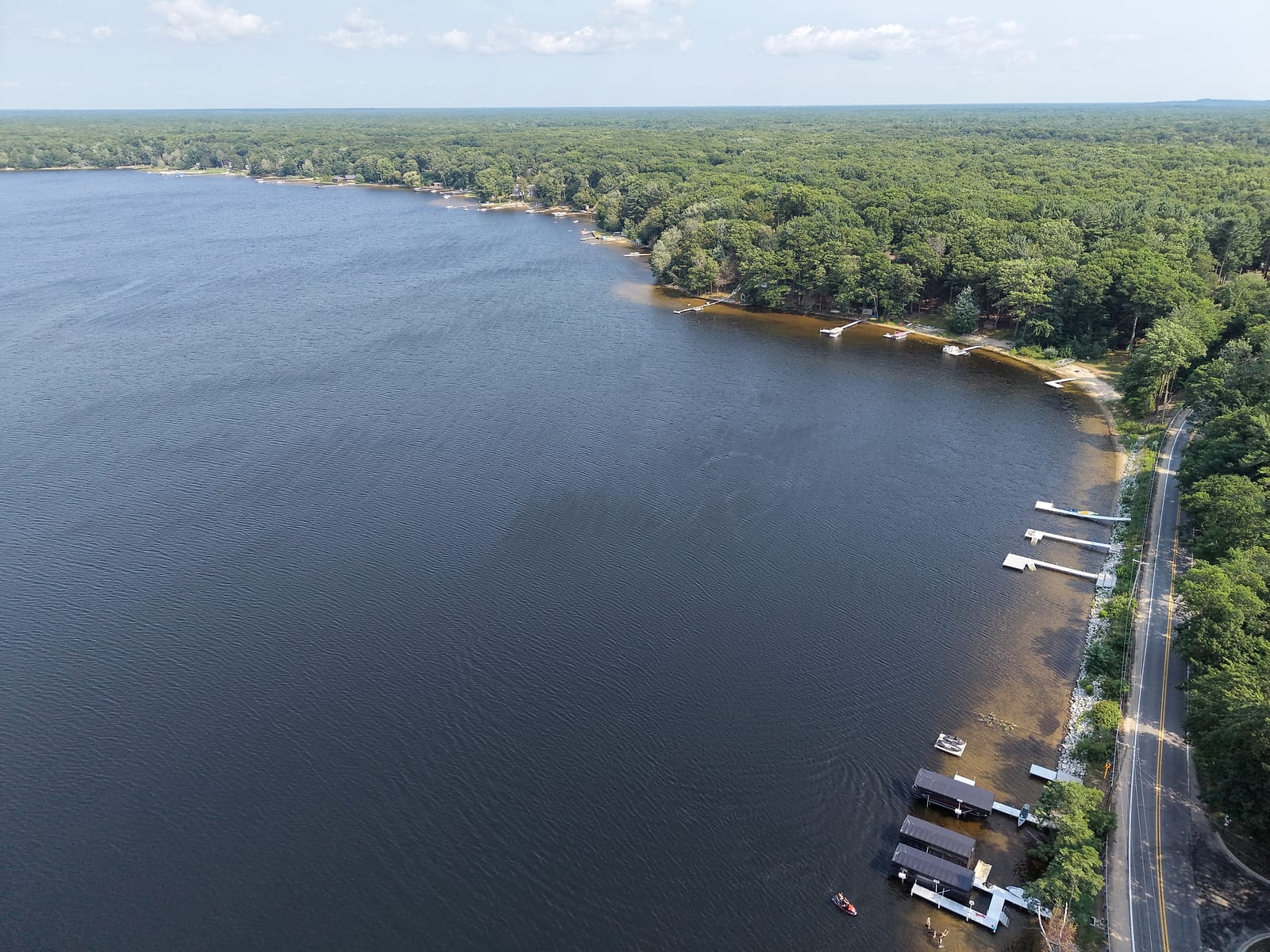 Aerial view along the Scenic Drive shoreline of Duck Lake with private docks and boathouses at the water's edge