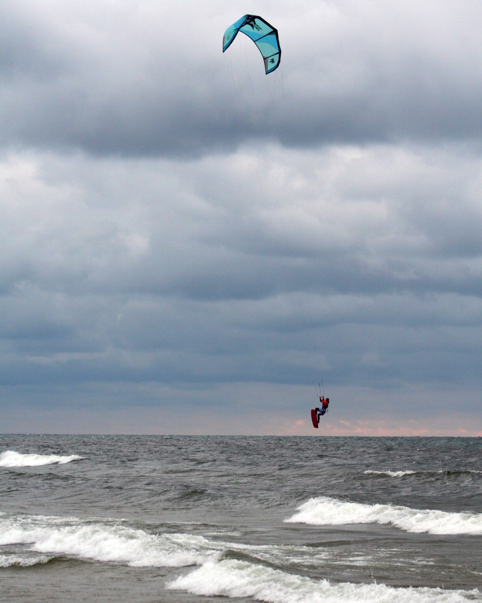 Kitboarder on Lake Michigan beach near Muskegon in big waves and dramatic sky