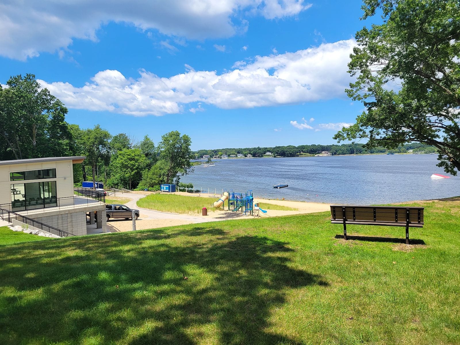 The Ross Park lakeside pavilion and playground on a grassy rise above Mona Lake