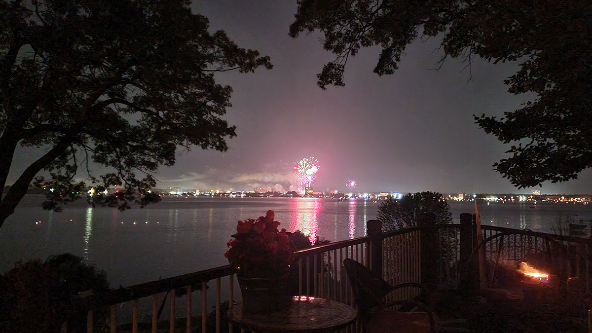Fourth of July fireworks over Muskegon Lake viewed from a North Muskegon deck