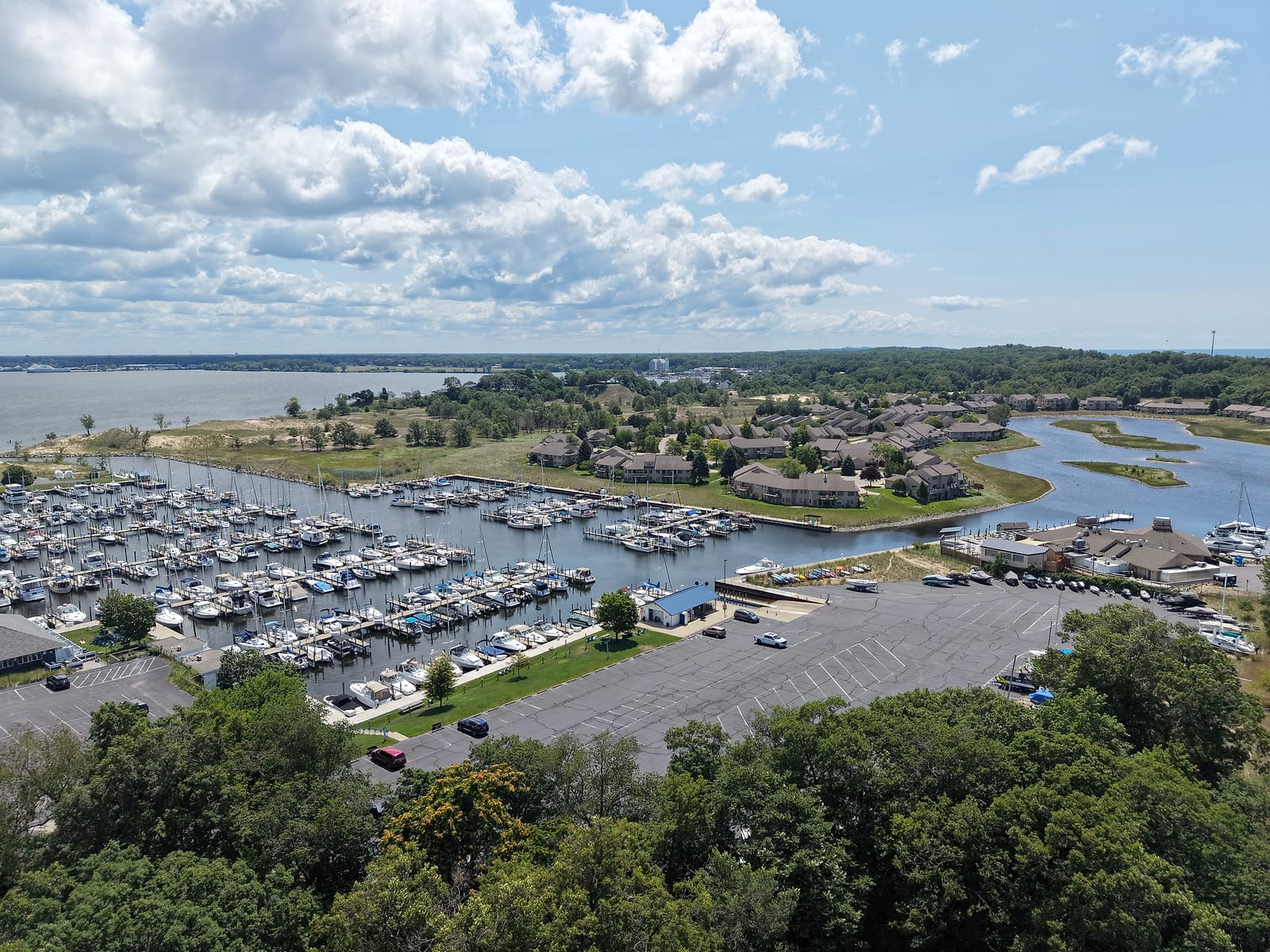 Harbour Towne from the air: the dockominium marina's slips and the BoDocks restaurant, with the condo buildings and their lagoons behind, and Muskegon Lake beyond