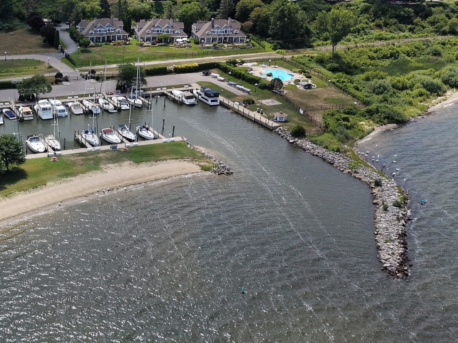 Lakeshore Harbour from the air: the three townhome buildings and pool behind Lakeshore Yacht Harbour's boat slips, inside the jettied harbor entrance on Muskegon Lake