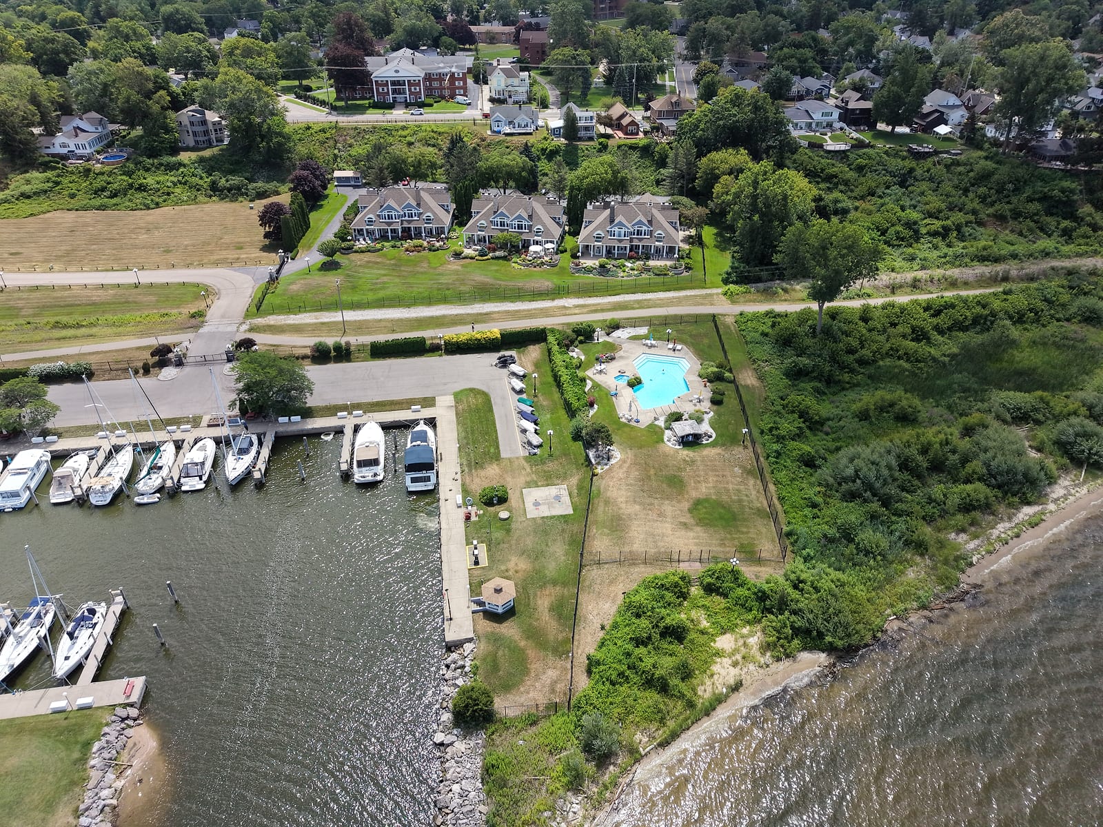 Lakeshore House, the brick building in the background across Lakeshore Drive, above a neighboring marina and waterfront condos at the Muskegon Lake shoreline