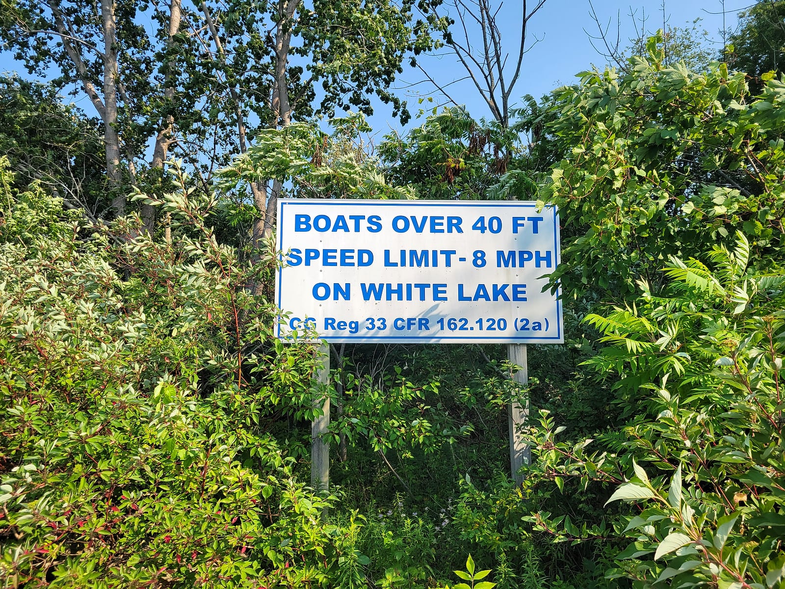 Posted sign at the White Lake channel reading Boats Over 40 Ft Speed Limit 8 MPH On White Lake, citing Coast Guard regulation 33 CFR 162.120